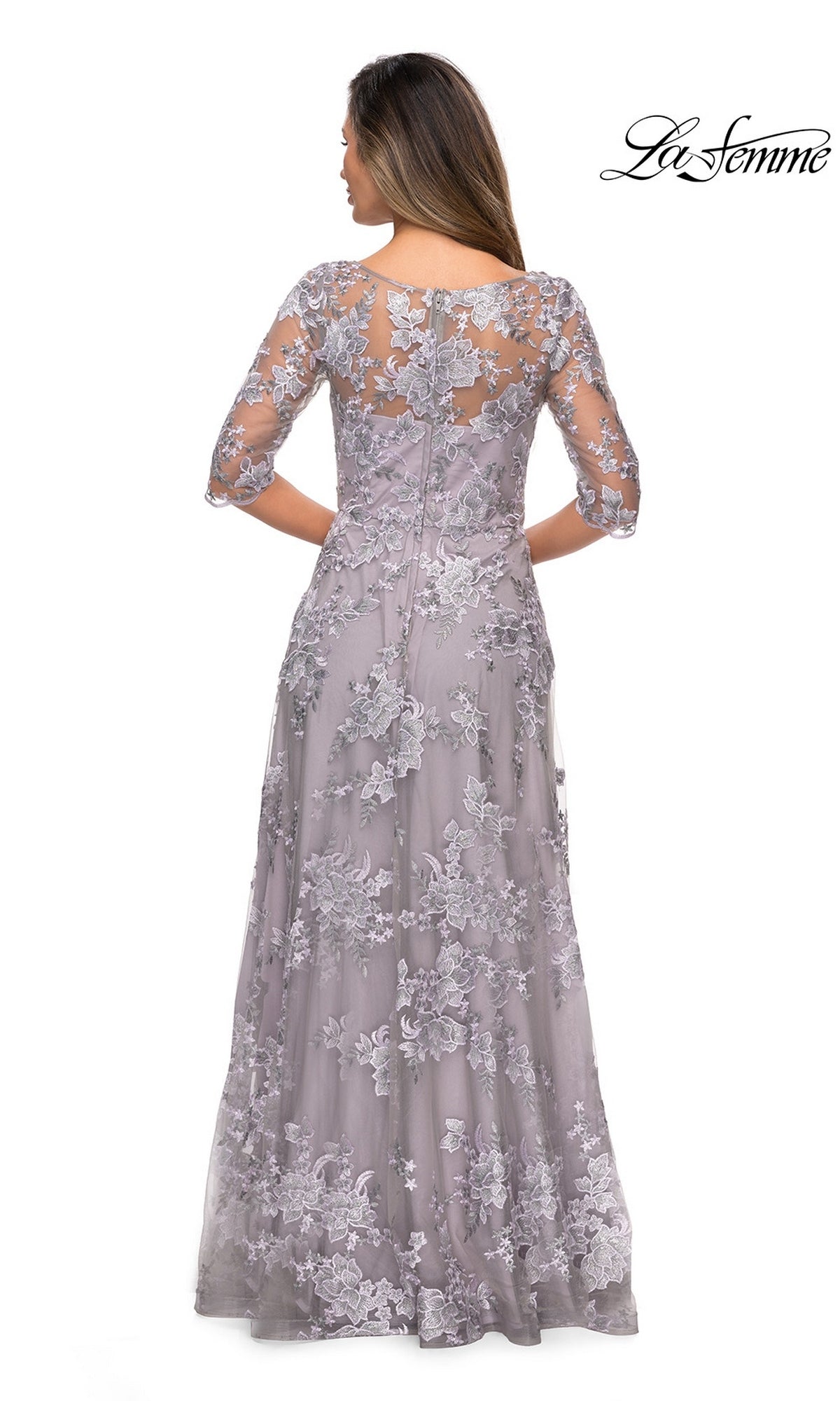 Woman in the Long Formal Dress: La Femme 27854, lavender with floral lace overlay and sheer three-quarter sleeves, shown from the back.
